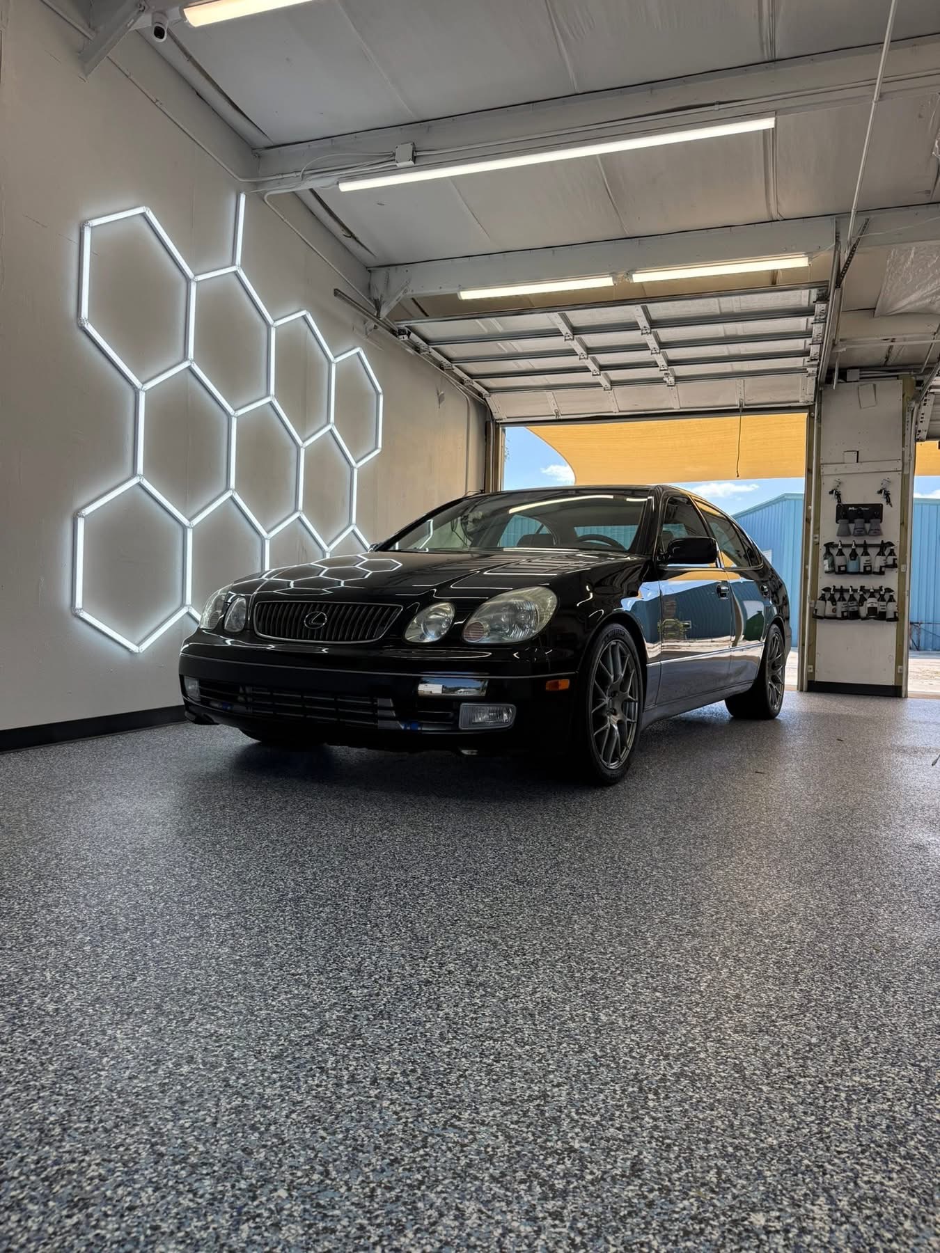 Black Lexus sedan beneath the hexagon lights from the Clean Sweep Detailing portfolio
